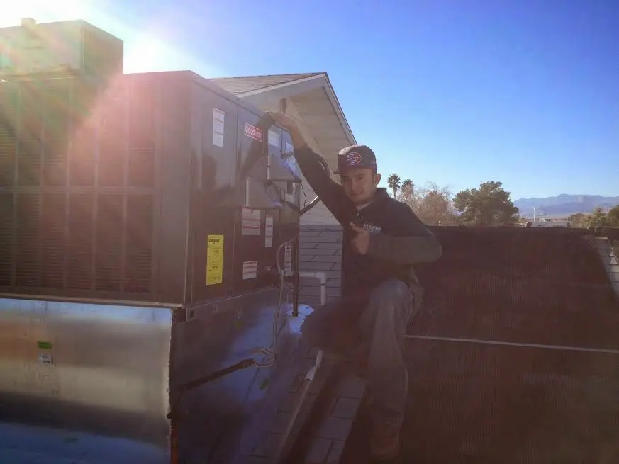 HVAC technician performing Boiler Repair on a rooftop unit in Danville